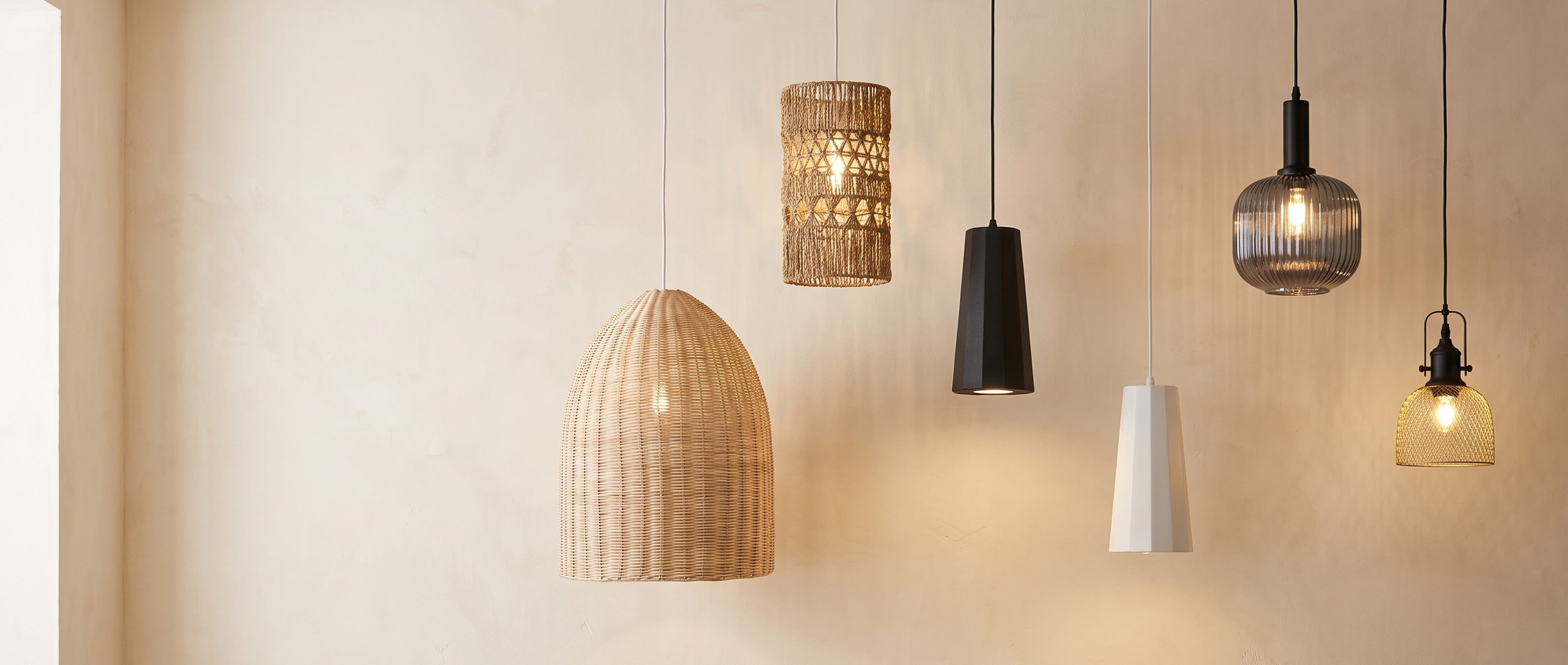 Pendant lighting fixtures hanging against a warm plaster wall